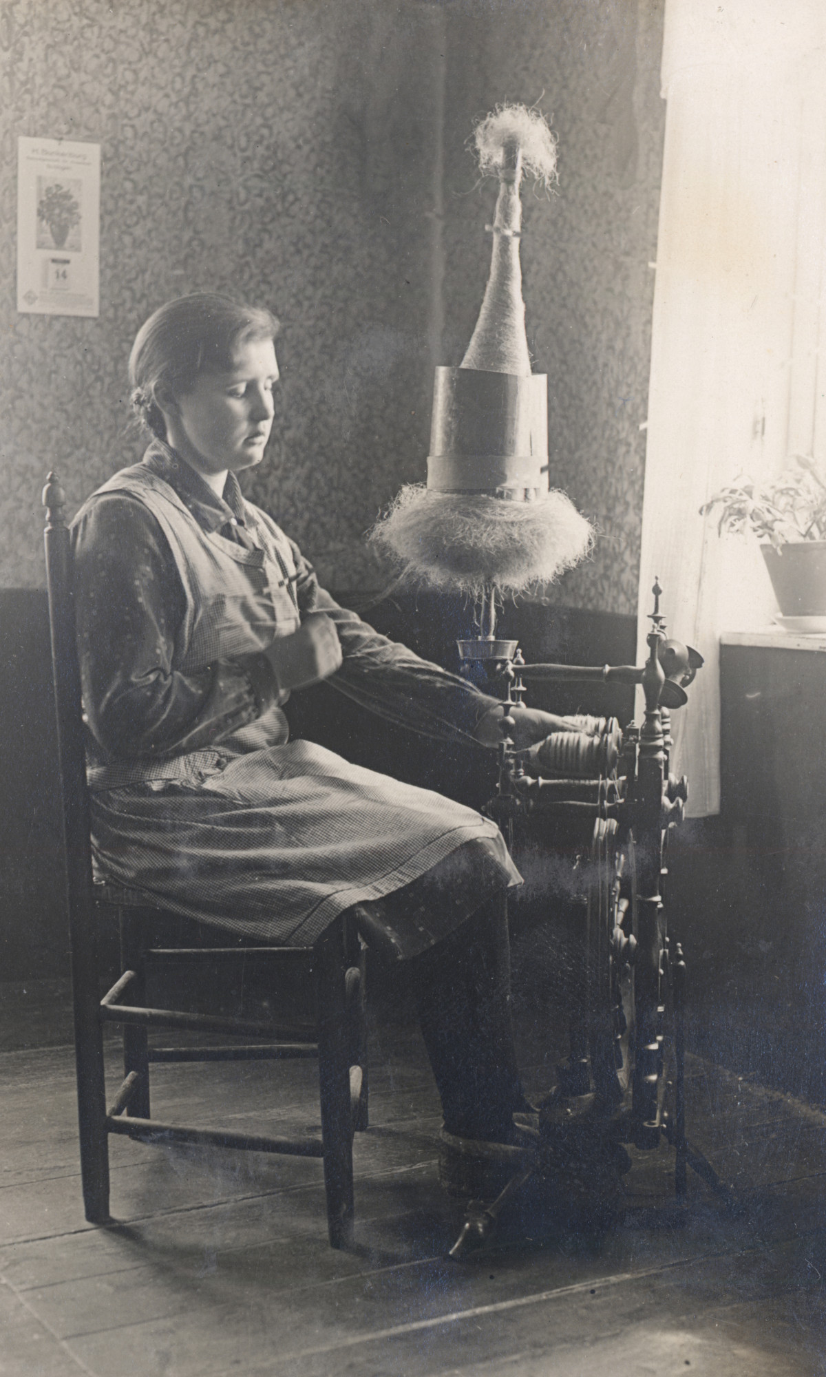 Frau Korte aus Vorwohlde an ihrem mit zwei Spulen ausgestatteten Bockspinnrad.